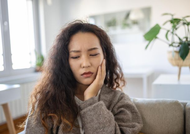 woman holding her face in pain